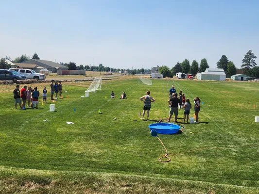 Youth gathered outside in a field with a pool