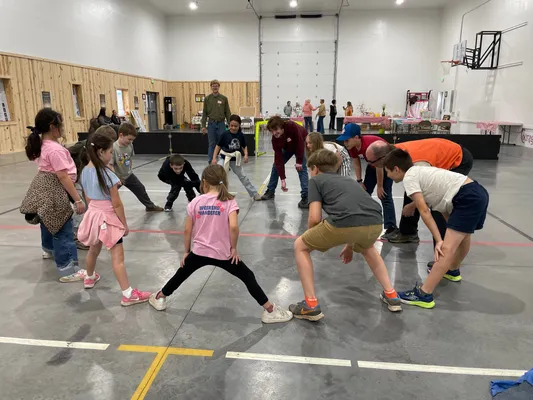Group of youth crouched in a circle playing a group game in the gym