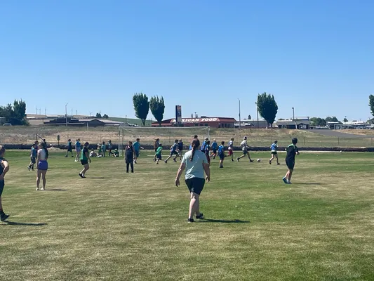 Youth on the soccer field with the goal in the distance.