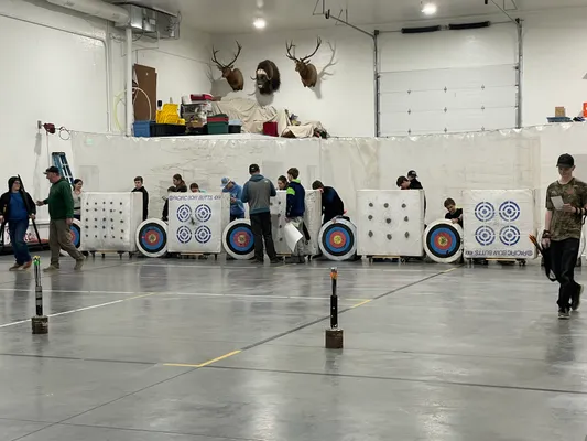 Youth retrieving arrows from archery targets