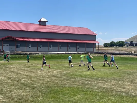 Youth playing soccer in front of the youth center.